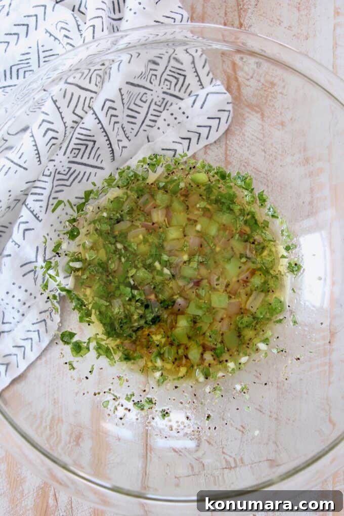 lemon herb dressing with sauteed vegetables in glass bowl