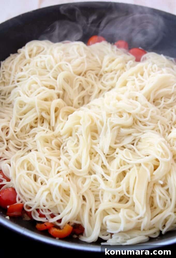 Caprese Pasta with Cherry Tomatoes, Mozzarella and Basil 9 cooked angel hair pasta in a skillet