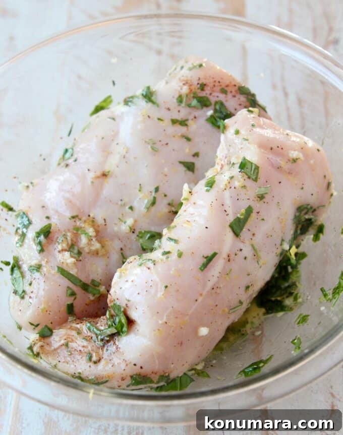 chicken breasts in bowl with lemon herb marinade
