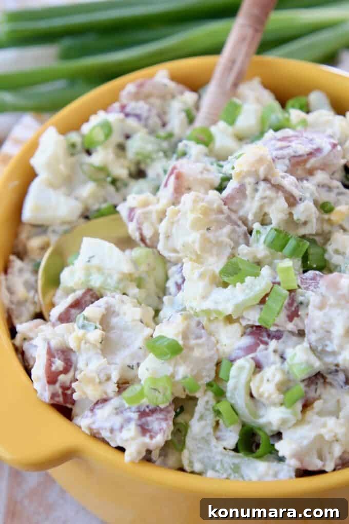 Instant Pot Cheddar Ranch Potato Salad Recipe 2 potato salad in yellow bowl with serving spoon