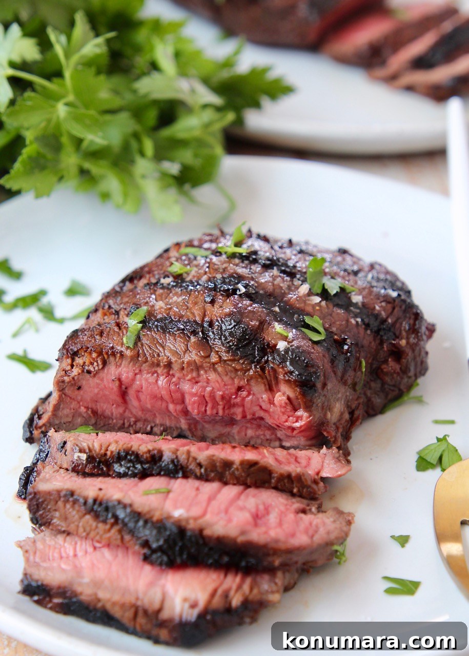 Sirloin Steak Marinade Recipe: Tender, Juicy Flavor 2 sliced grilled steak on plate, topped with fresh chopped parsley