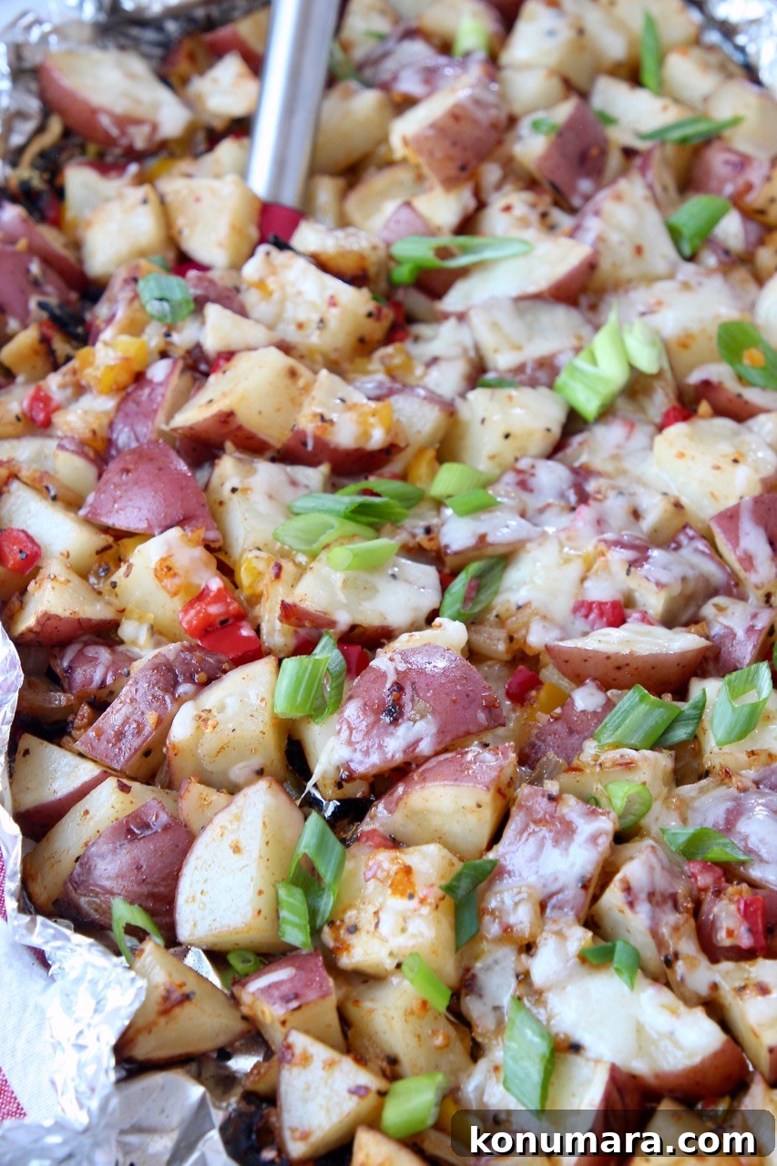 grilled cubed potatoes in foil topped with diced green onions