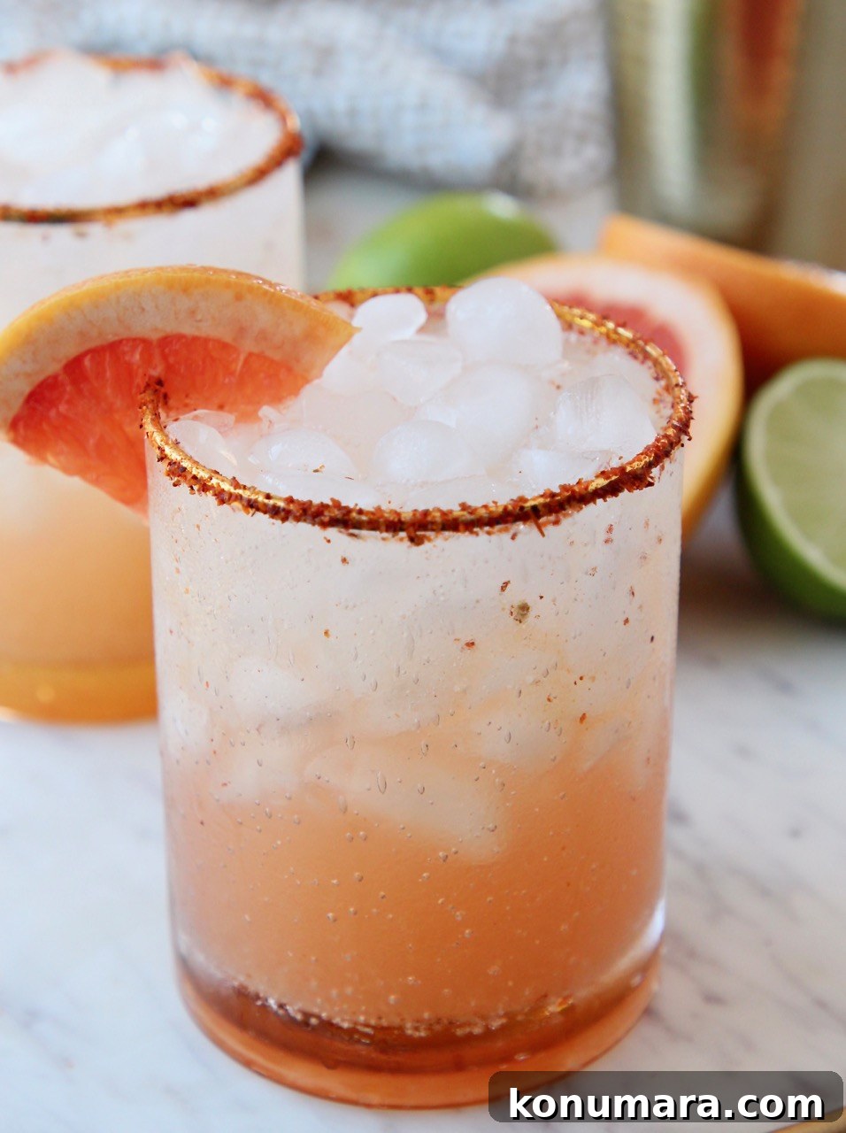 paloma in glass with tajin on the rim and grapefruit wedge on the edge of the glass