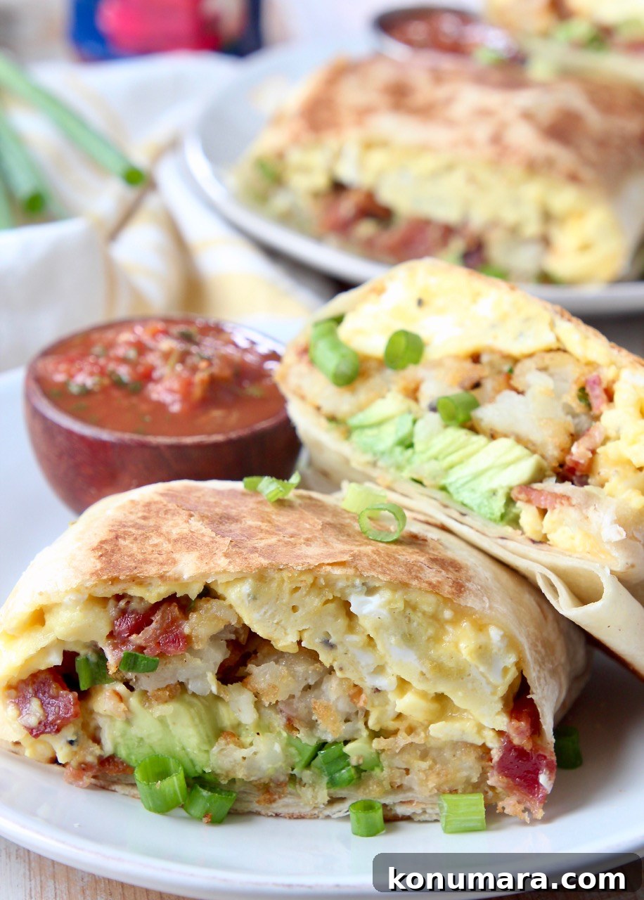 burritos sliced in half on plates with small bowl of salsa
