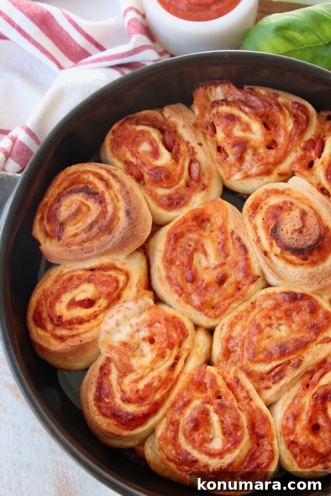 Crispy Homemade Pizza Rolls with Gooey Cheese 7 pizza rolls in black baking dish