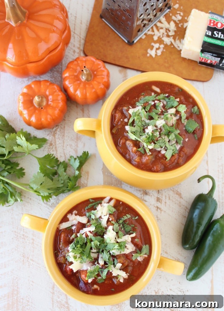 Pumpkin Chili Recipe with Black Beans 10 Two yellow bowls filled with Pumpkin Chili garnished with melted cheese and cilantro.