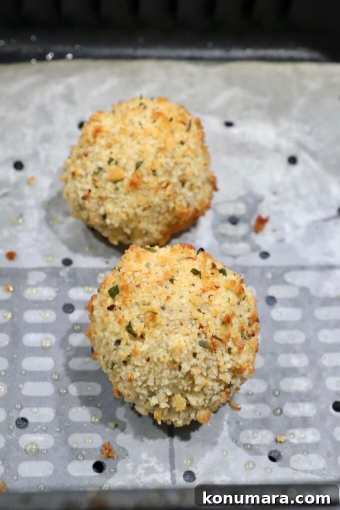 cooked arancini in air fryer basket