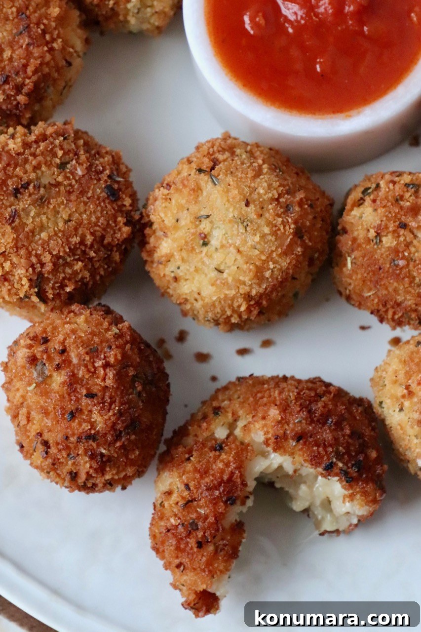 arancini on plate with marinara sauce in bowl