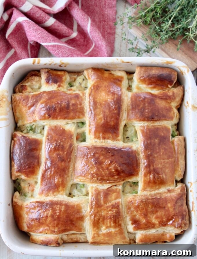 baked chicken pot pie in a square baking dish topped with a woven puff pastry crust