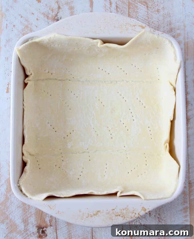 puff pastry dough pressed into a square baking dish
