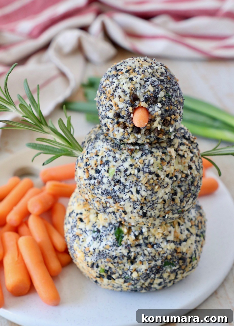 cheese ball snowman on serving tray with carrot sticks