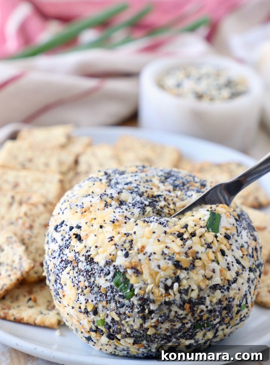 cheese ball on plate with spreader stuck in the cheese ball