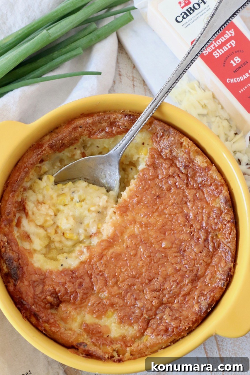 corn casserole in yellow baking dish with serving spoon