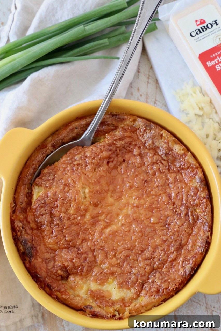 corn casserole in baking dish with serving spoon