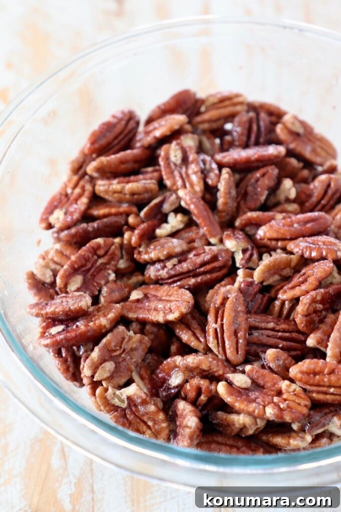 pecans coated in egg white in glass bowl