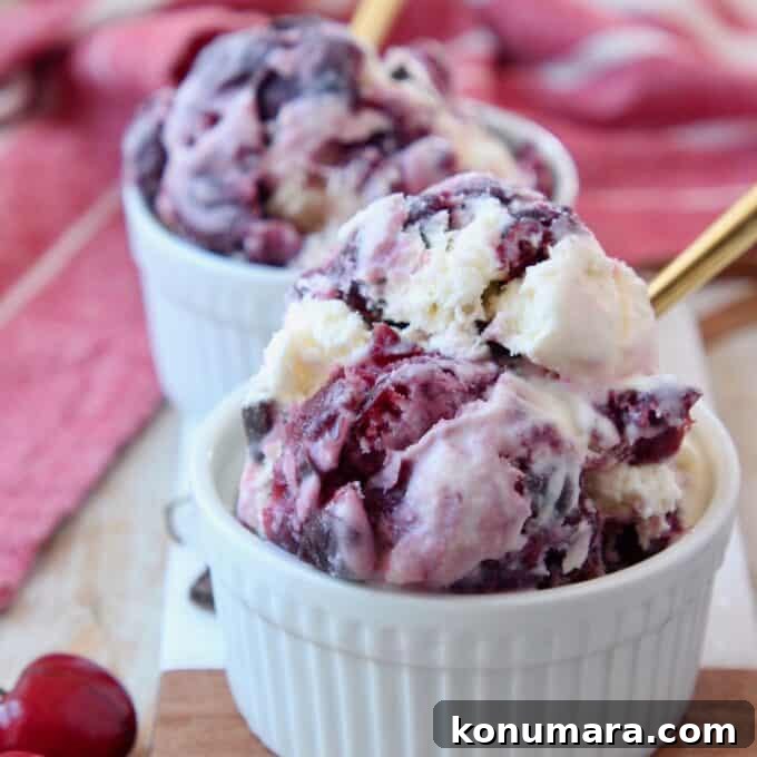 scoops of cherry ice cream in bowl with gold spoon