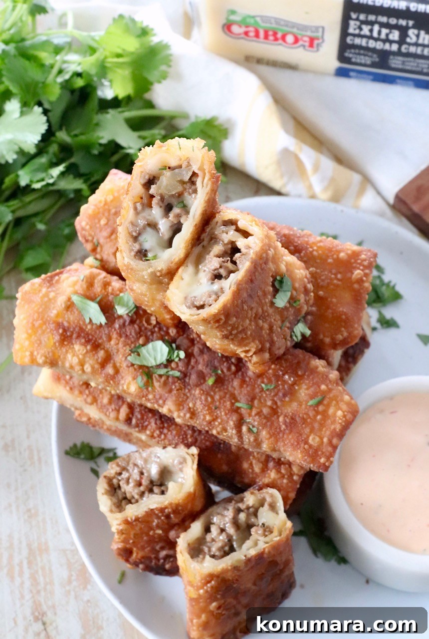cheeseburger egg rolls cut in half on plate