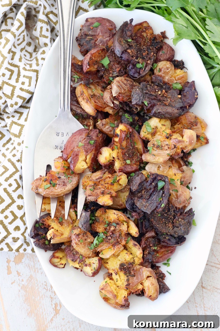 Crispy Smashed Potatoes Recipe with Garlic and Herbs 7 crispy smashed potatoes on plate with large serving fork