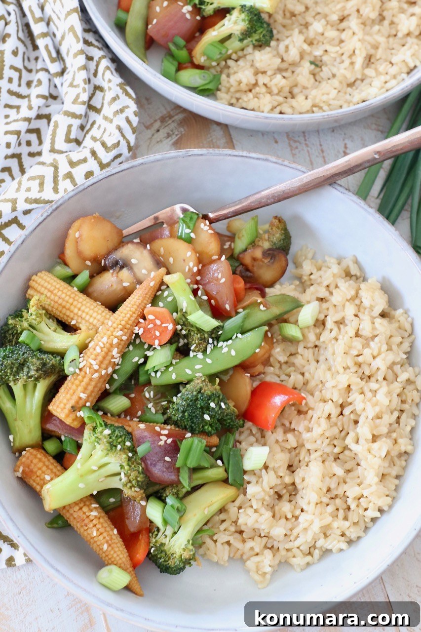 Crispy Garlic and Ginger Stir-Fried Vegetables Recipe 2 stir fry vegetables in bowl with brown rice and fork
