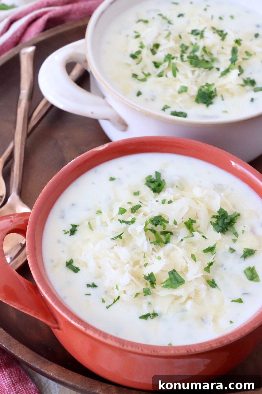 potato soup in bowls topped with shredded cheese and chopped parsley