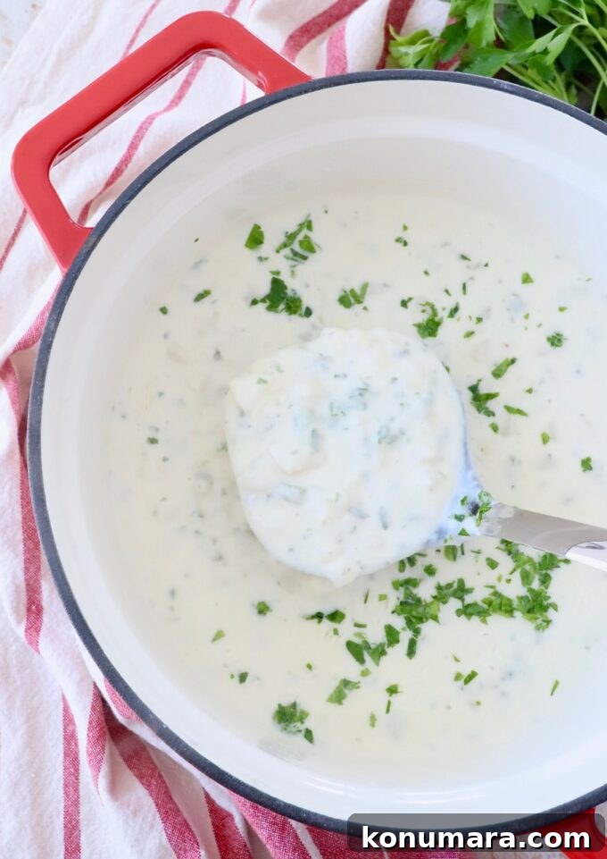 potato soup in a large pot with a ladle dipping into the soup