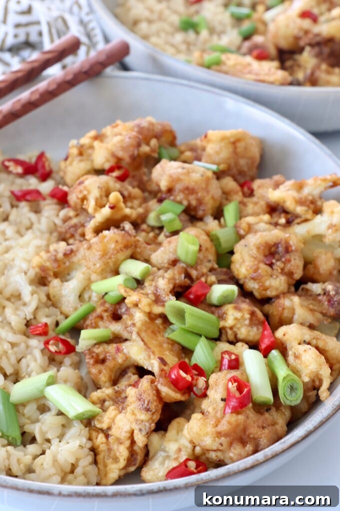 General Tso's Cauliflower Recipe: Crispy Sticky Sauce 7 fried general tso cauliflower in bowl with diced red chilies and green onions