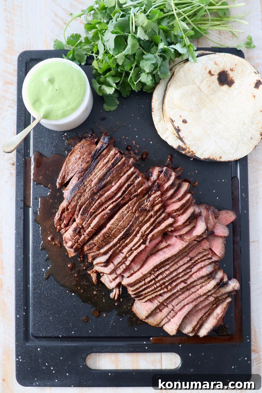 sliced steak on cutting board with sauce and tortillas