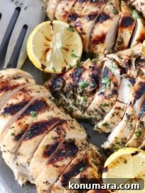 sliced grilled chicken on plate with lemons