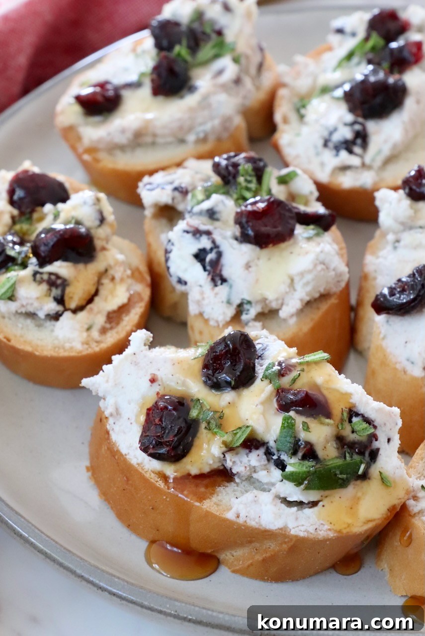 Cranberry goat cheese crostini drizzled with honey on a plate