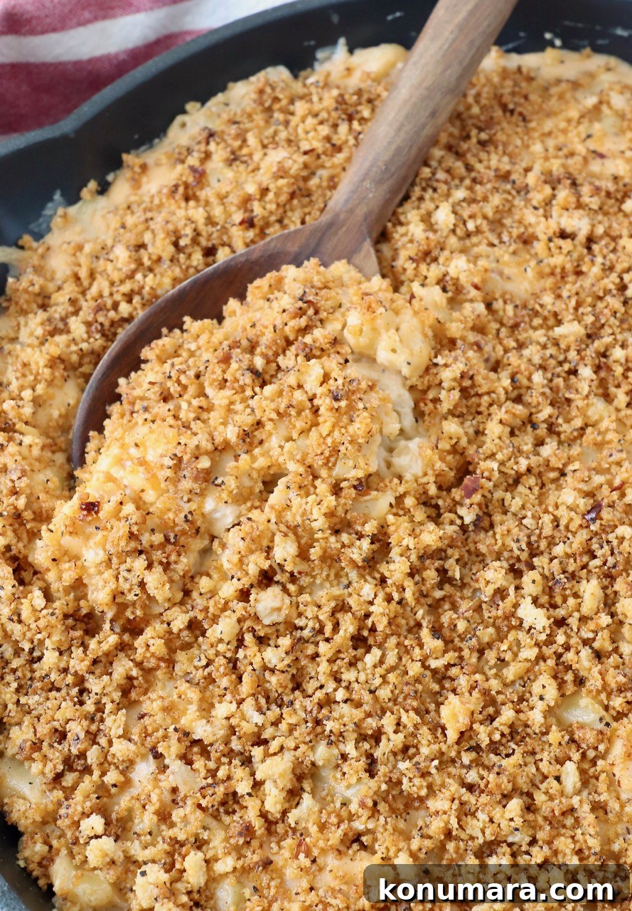 serving spoon in skillet of smoked mac and cheese
