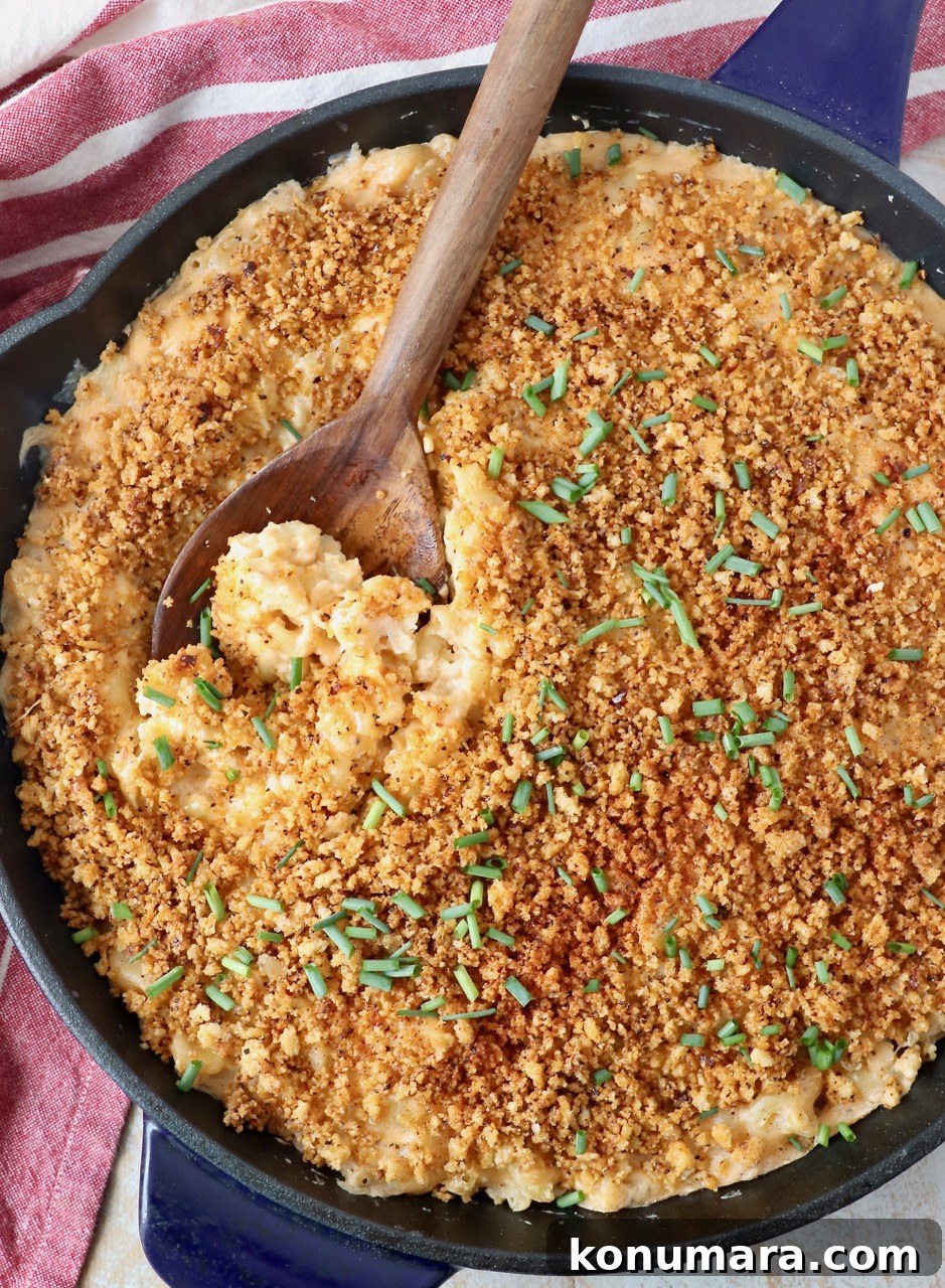 mac and cheese in large skillet with wooden serving spoon