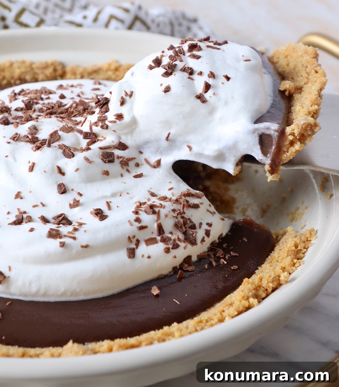 slice of pie lifted out of chocolate pie with whipped cream topping