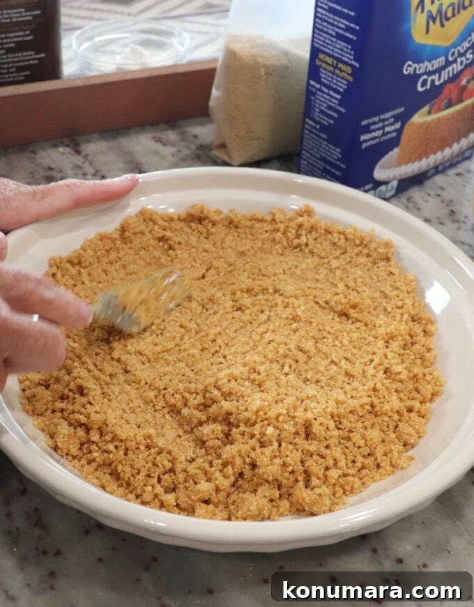 graham cracker crust being prepared in pie plate