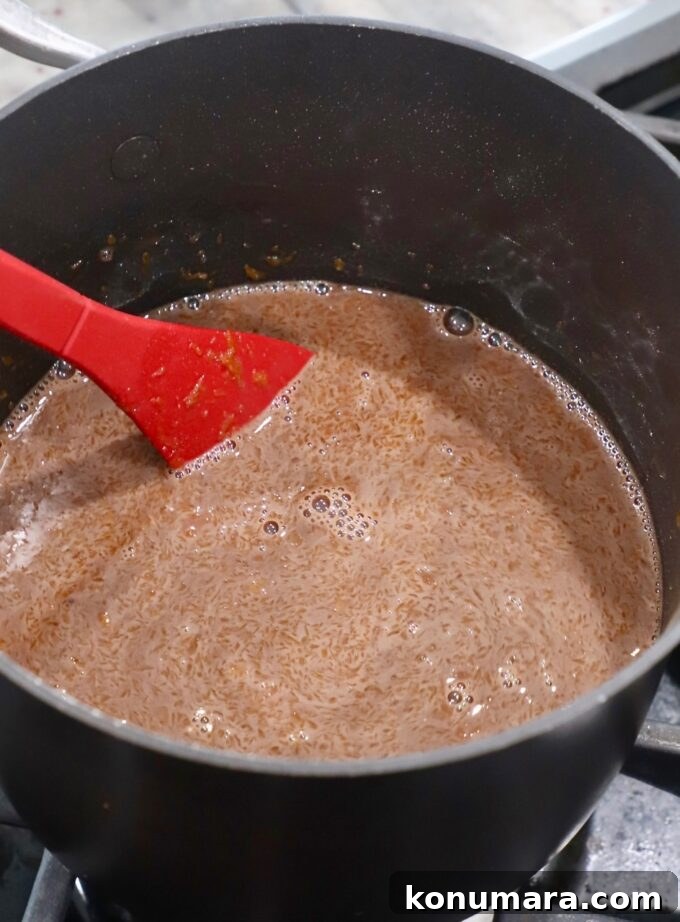 red spoon stirring chocolate filling in saucepan