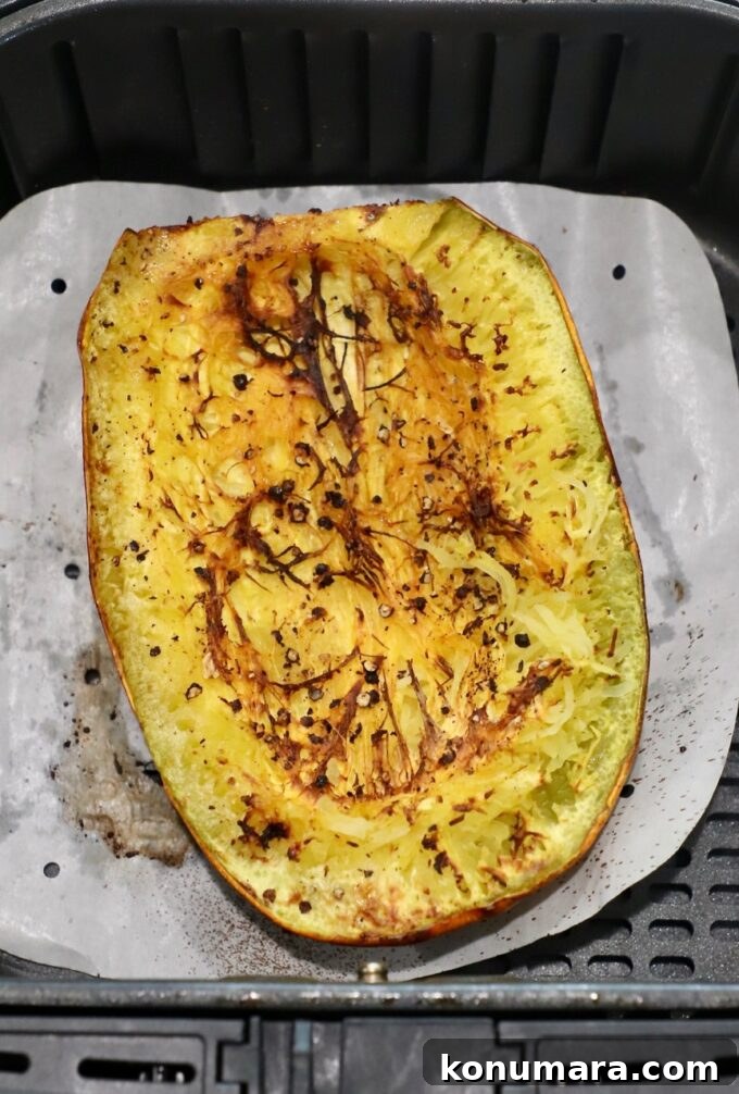 cooked spaghetti squash half in air fryer basket