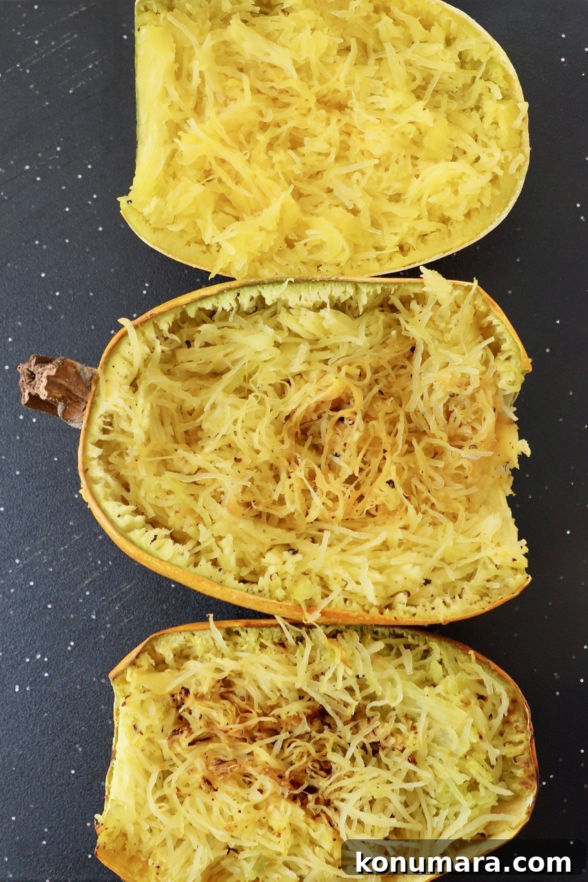 three halves of cooked spaghetti squash on cutting board