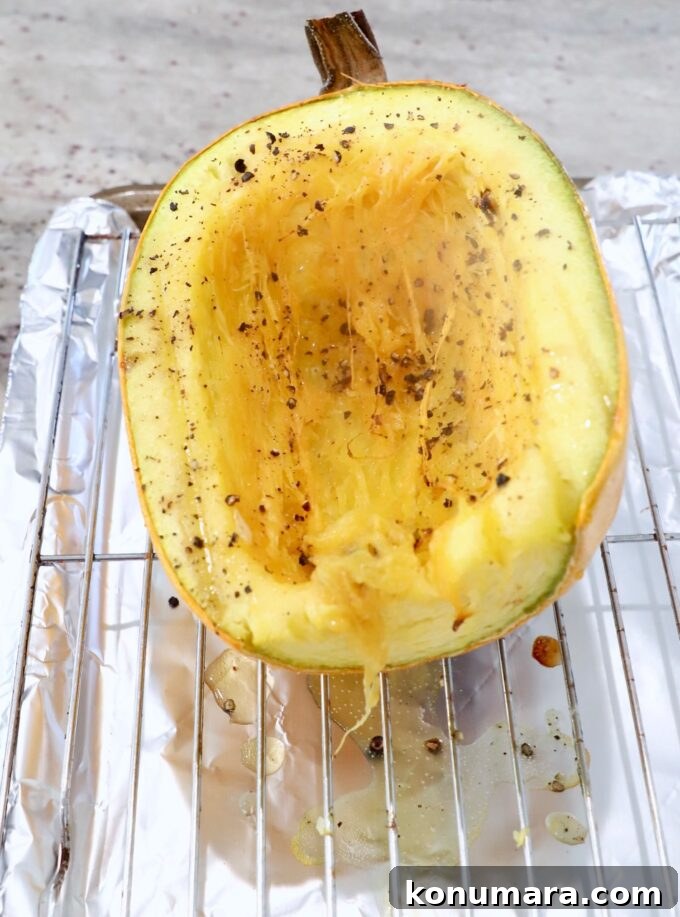 roasted spaghetti squash half sitting on wire rack on top of a baking sheet