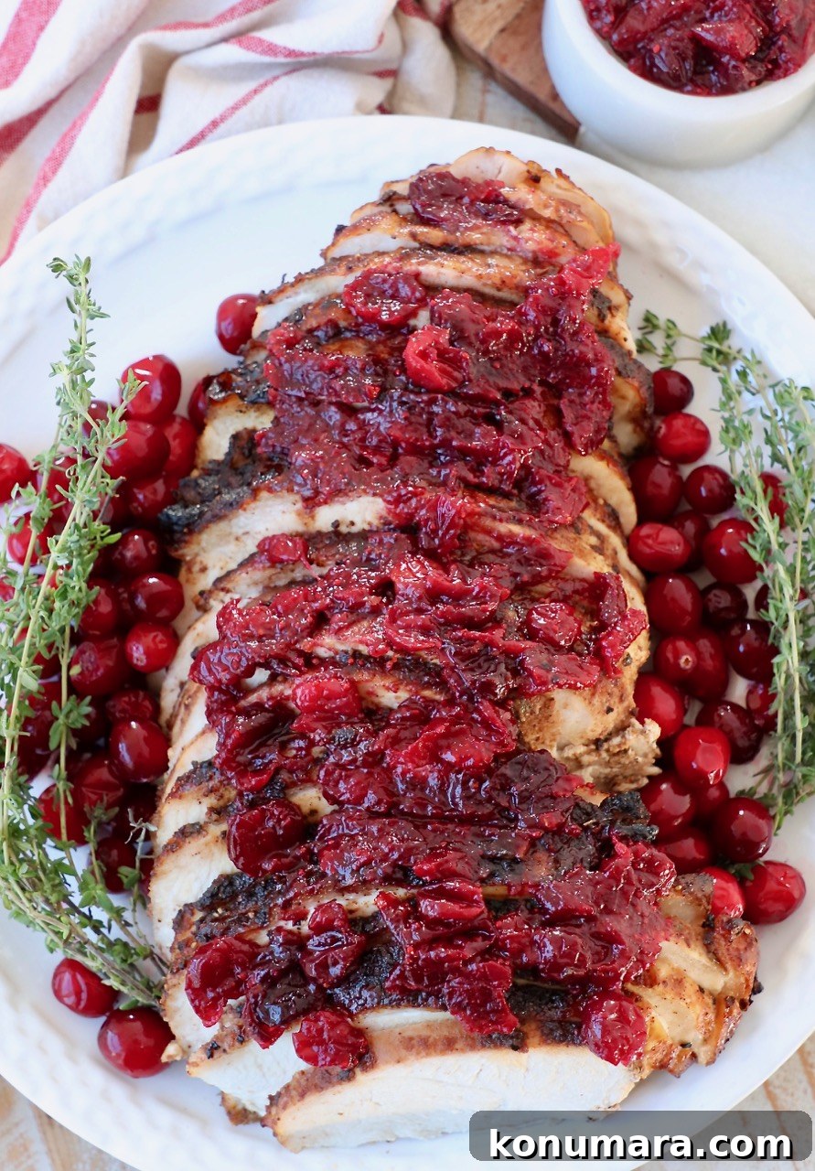 sliced turkey breast on plate with fresh cranberries and thyme
