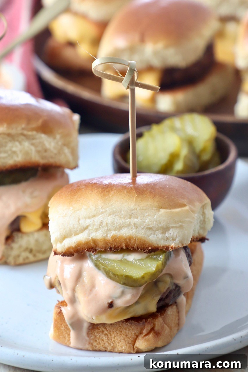 Juicy Cheeseburger Sliders Recipe with Caramelized Onions 5 cheeseburger sliders on plate with pickles