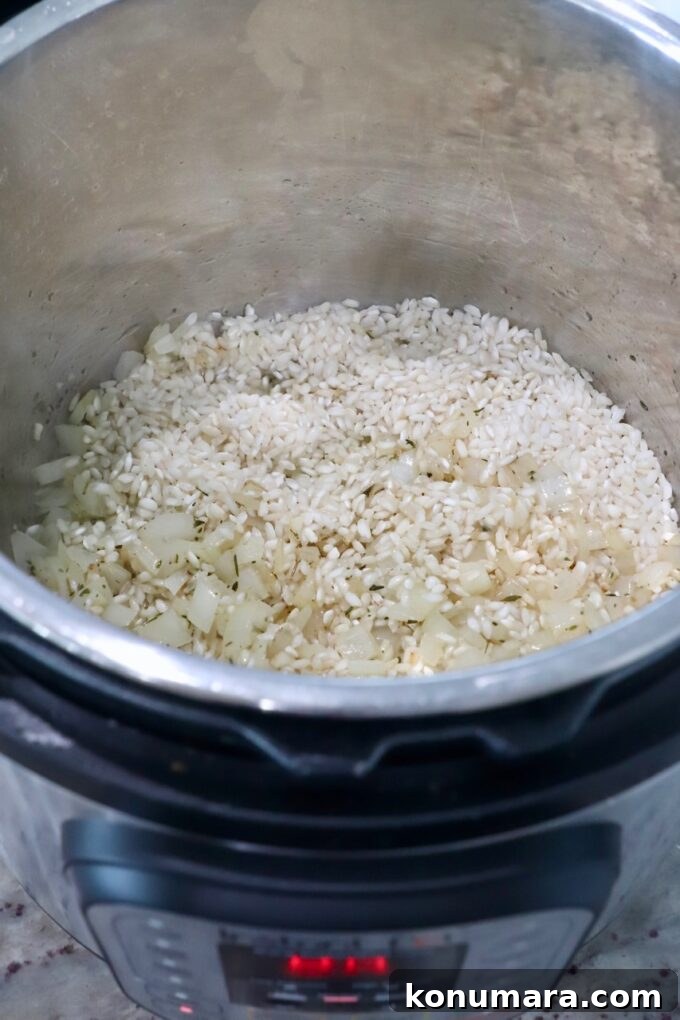 Creamy Instant Pot Risotto Recipe 5 arborio rice in Instant Pot with cooked onions