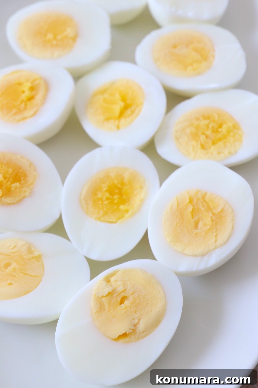 How to Hard-Boil Eggs: Foolproof Method for Perfect Yolks 2 hard boiled eggs sliced in half on white plate