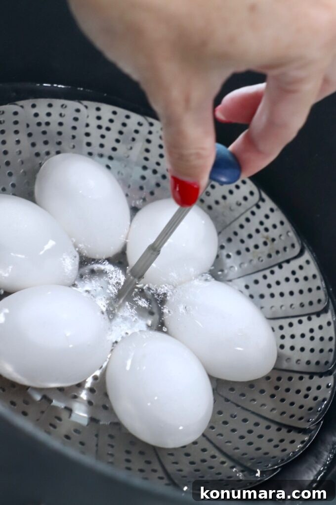 How to Hard-Boil Eggs: Foolproof Method for Perfect Yolks 5 hand lowering eggs in steamer basket into pot of boiling water