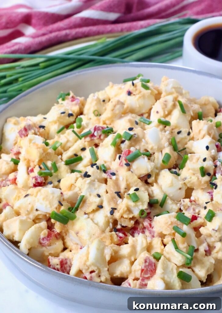 How to Hard-Boil Eggs: Foolproof Method for Perfect Yolks 10 miso egg salad in a bowl topped with chopped chives and sesame seeds