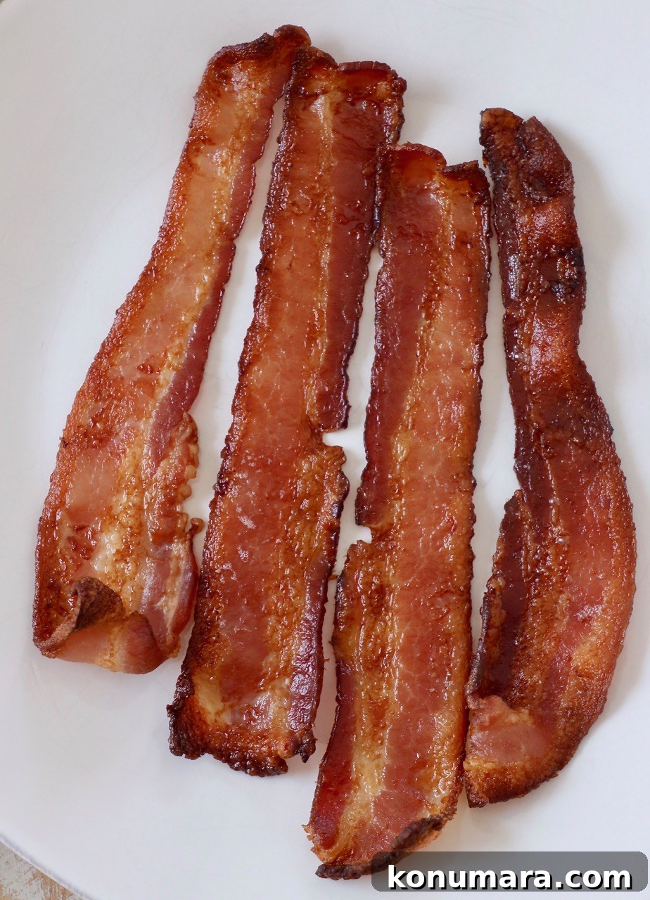 How to Cook Bacon in the Oven for Crispy, Even Results 2 cooked bacon on white plate