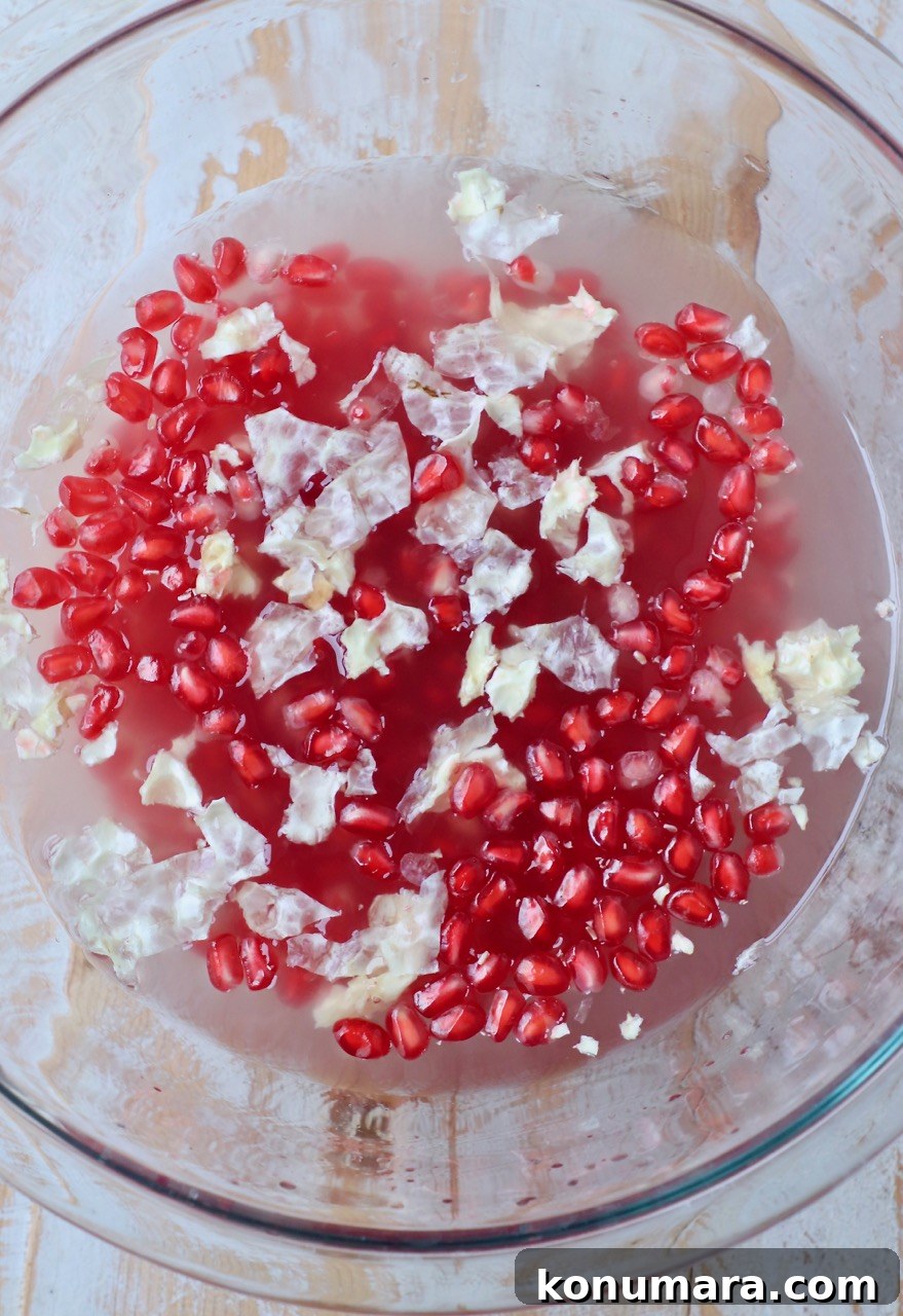 pomegranate seeds in glass bowl of water