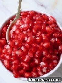 pomegranate arils in bowl with spoon