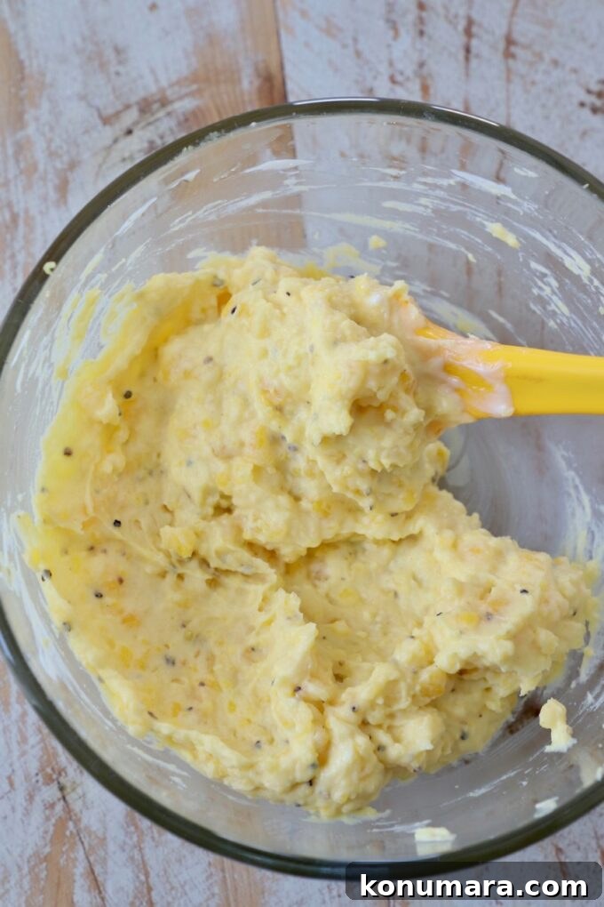 filling for deviled eggs in glass bowl with yellow spatula