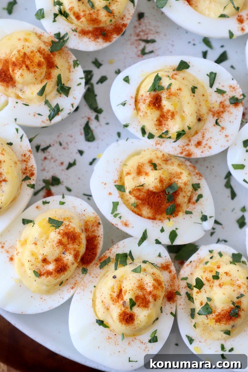 overhead image of deviled eggs on plate topped with fresh chopped parsley