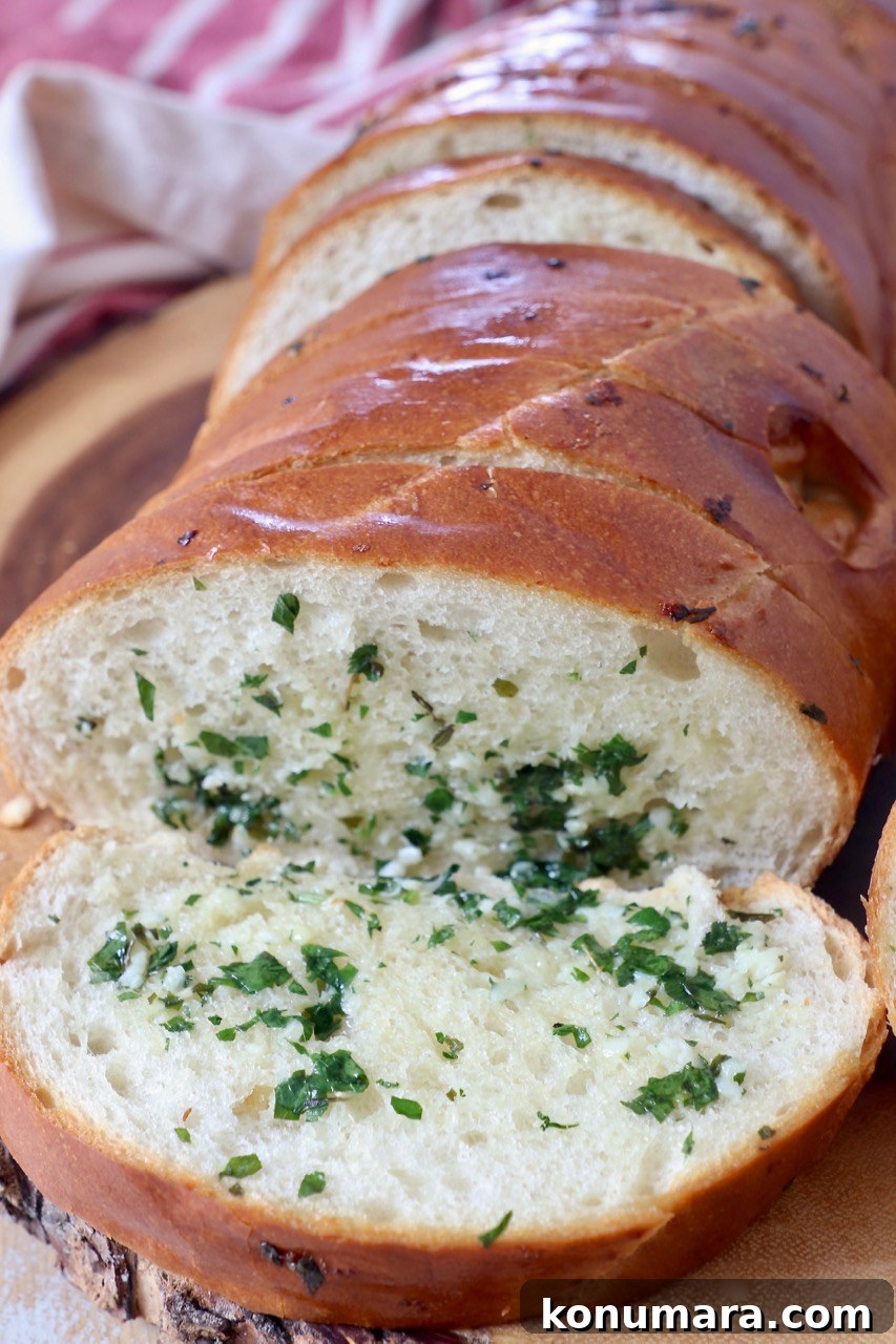 Crispy Garlic Bread with Herbed Butter 2 sliced garlic bread on wood cutting board