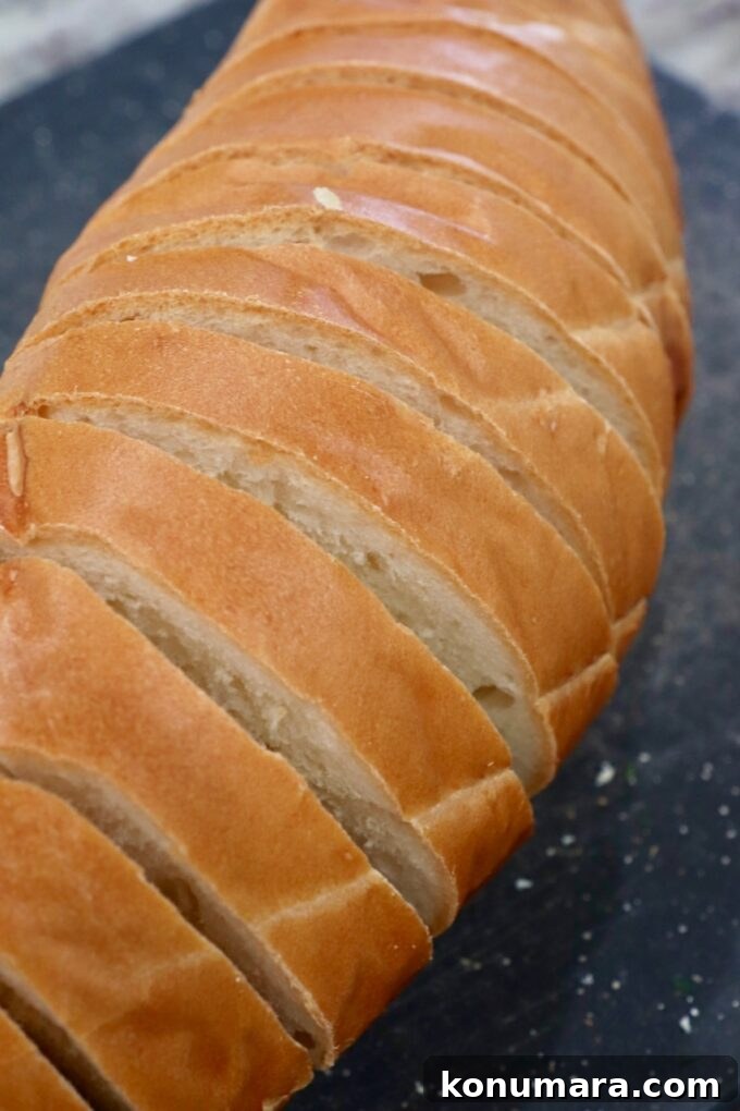 Crispy Garlic Bread with Herbed Butter 7 french loaf of bread sliced on a cutting board